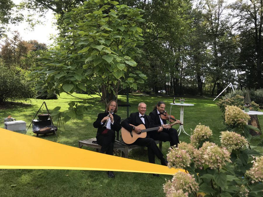 Drei Männer spielen im Park Musik